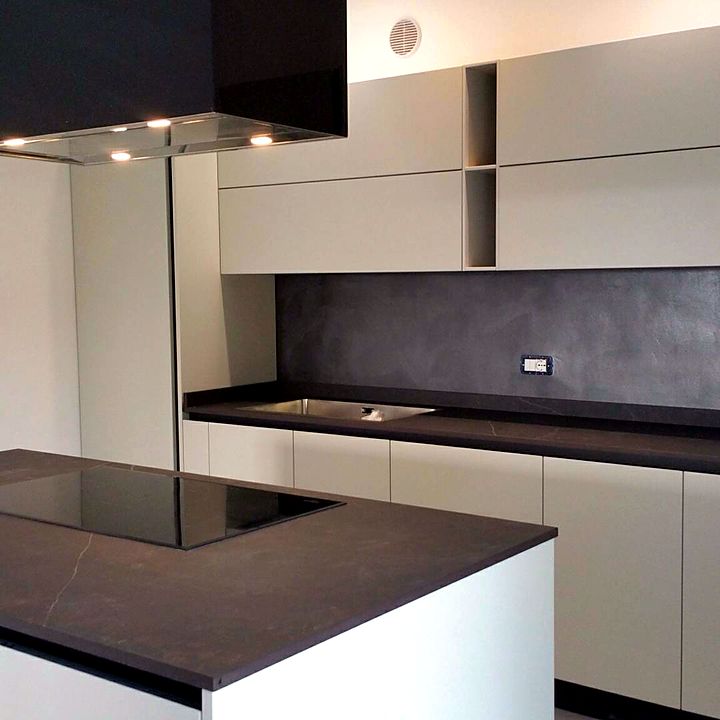Cucina con isola e cappa nera sospesa